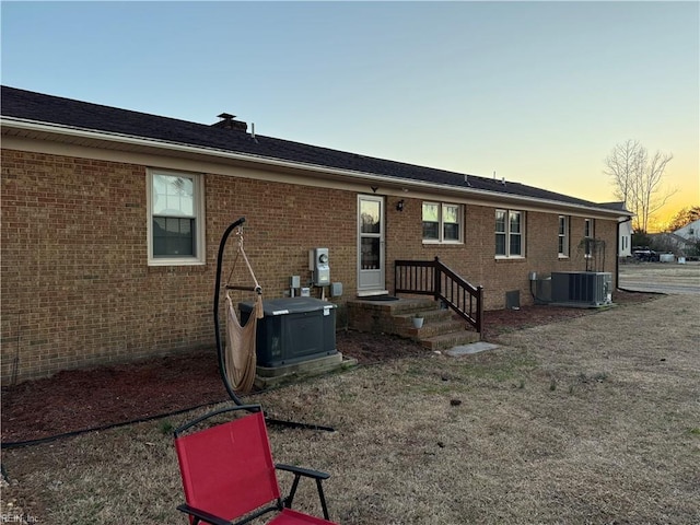 back of property with central AC and brick siding