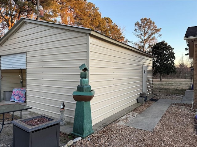 view of side of home with a fire pit and an outbuilding