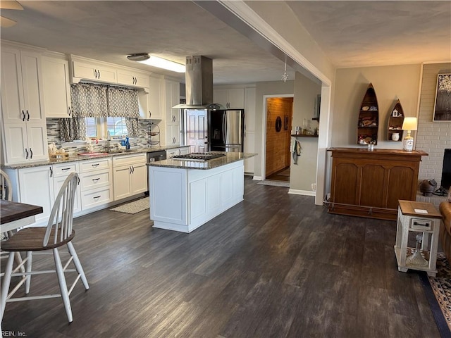 kitchen with stone counters, dark wood-style floors, island exhaust hood, appliances with stainless steel finishes, and white cabinetry