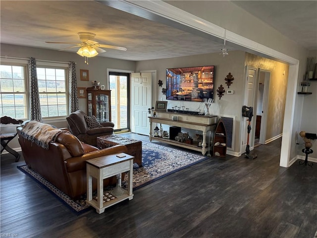 living room with a ceiling fan, wood finished floors, visible vents, and baseboards