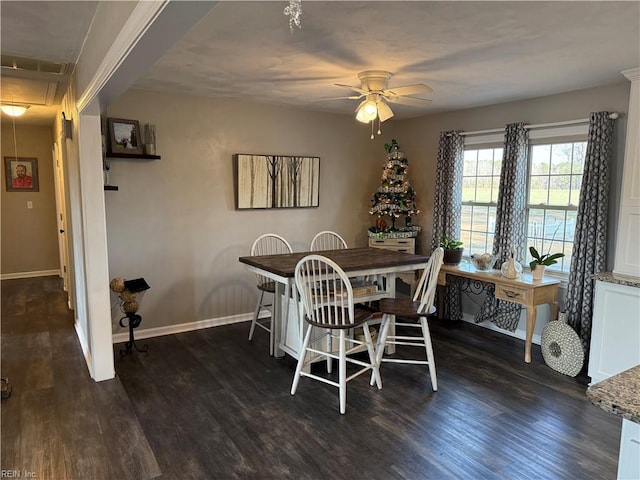 dining room featuring dark wood-type flooring, attic access, baseboards, and a ceiling fan