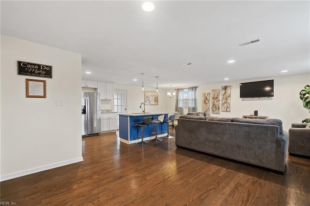 living area featuring dark wood-style floors, baseboards, visible vents, and recessed lighting