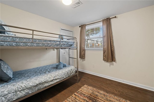 bedroom with wood finished floors, visible vents, and baseboards