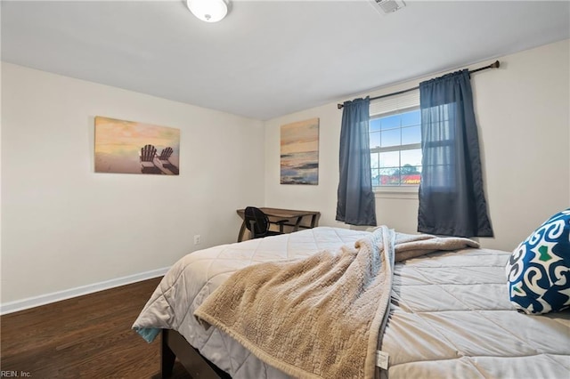 bedroom with wood finished floors, visible vents, and baseboards