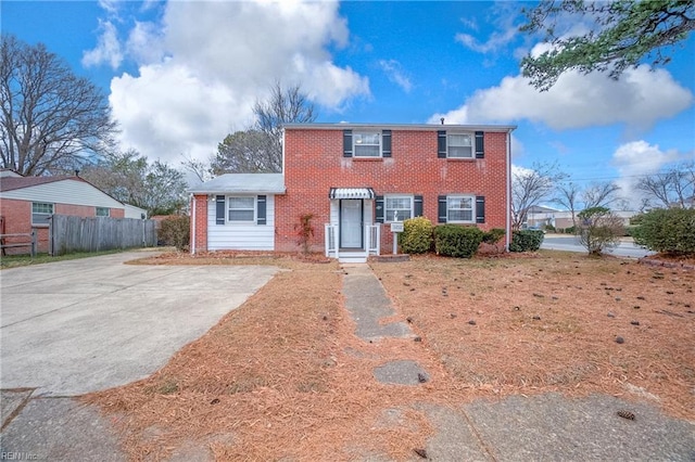 colonial house featuring brick siding and fence