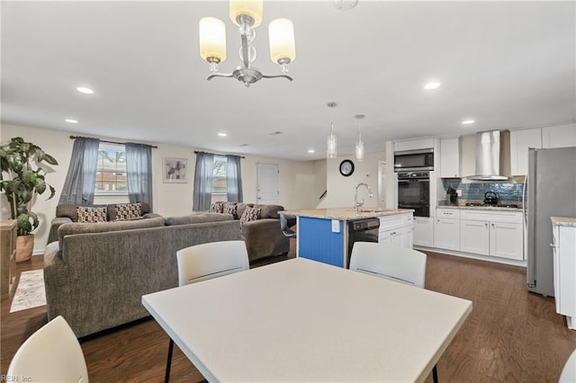 dining space with dark wood-style floors, recessed lighting, and an inviting chandelier