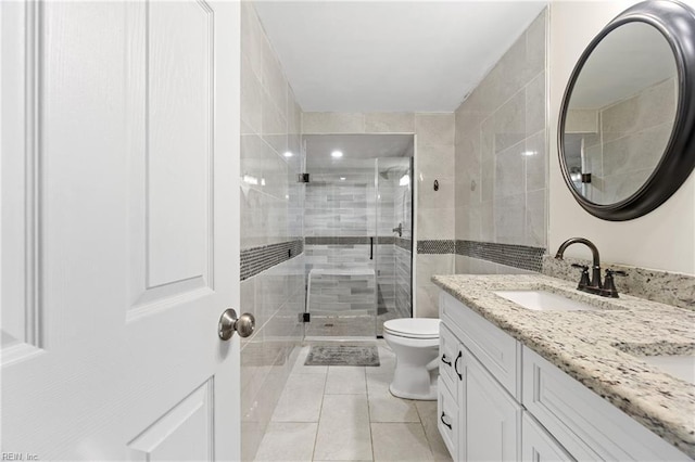 full bathroom featuring a stall shower, vanity, toilet, and tile patterned floors