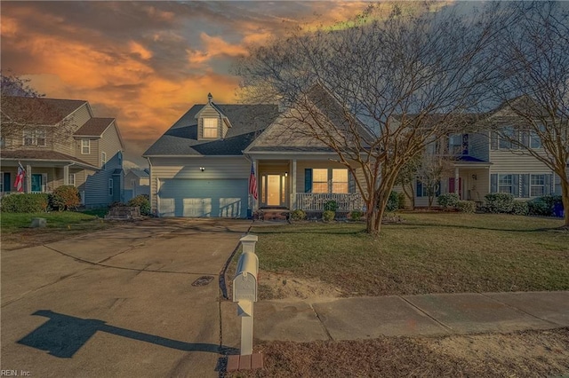 view of front facade with an attached garage, a porch, concrete driveway, and a front yard