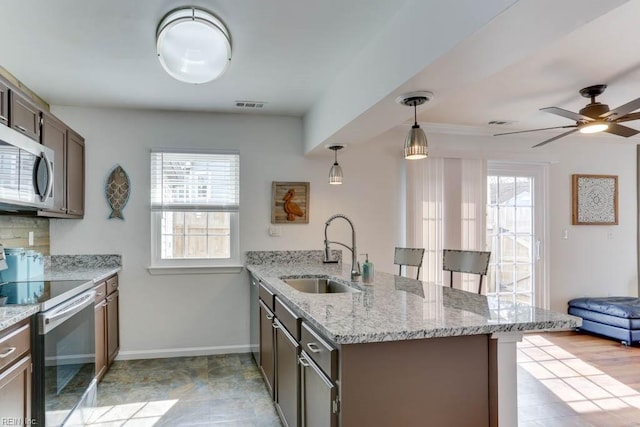 kitchen with tasteful backsplash, visible vents, appliances with stainless steel finishes, a sink, and a peninsula