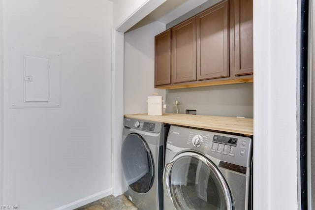 laundry room with electric panel, cabinet space, baseboards, and washing machine and clothes dryer