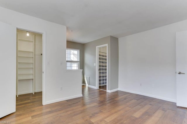 unfurnished room with wood finished floors and baseboards