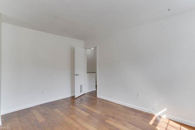 unfurnished room featuring baseboards and wood finished floors