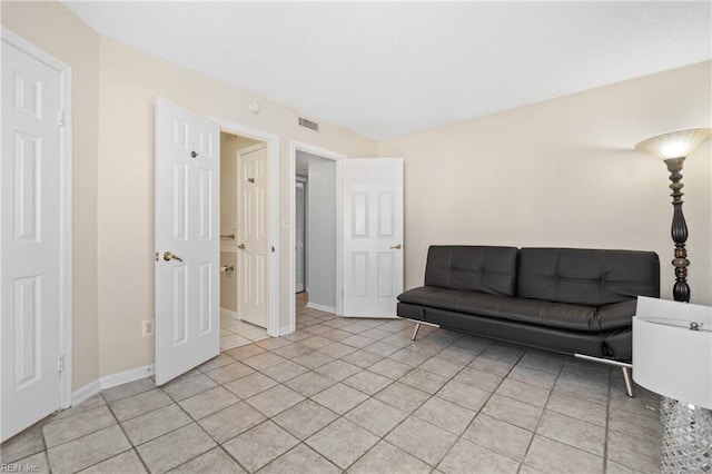 living room with light tile patterned floors, baseboards, and visible vents