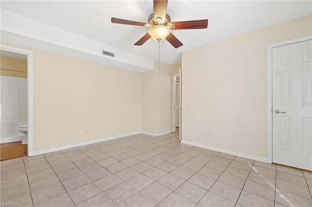 spare room with a ceiling fan, visible vents, and baseboards