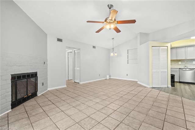 unfurnished living room with visible vents, baseboards, ceiling fan, vaulted ceiling, and a fireplace