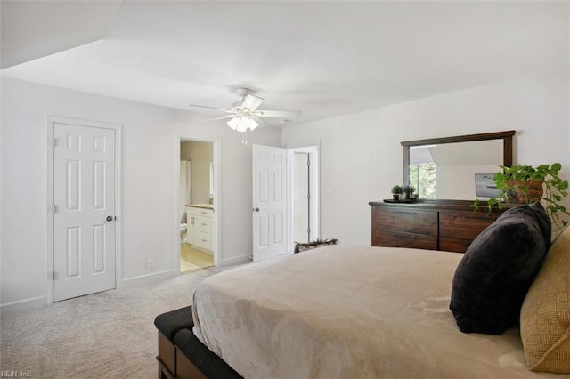 bedroom with light carpet, ceiling fan, connected bathroom, and baseboards