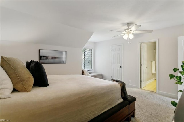 carpeted bedroom with ensuite bath, a ceiling fan, and baseboards