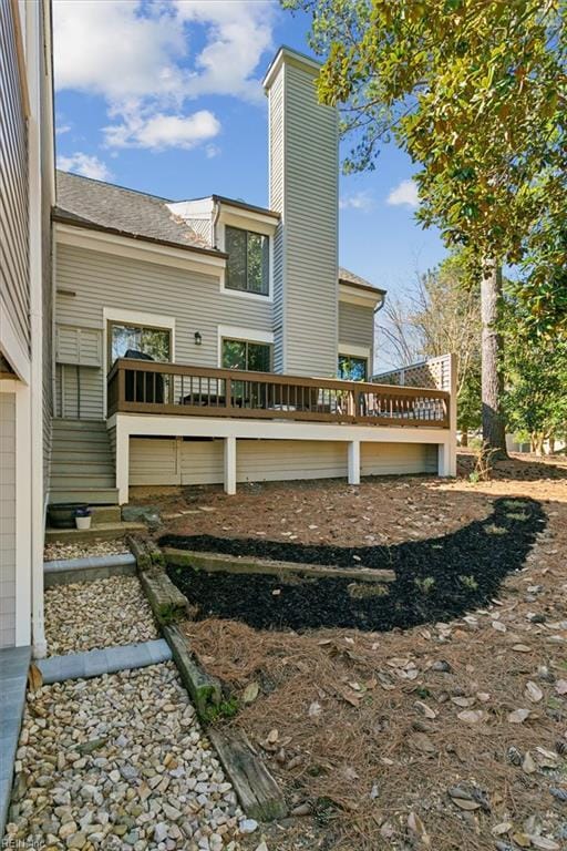 rear view of house with a deck and a chimney