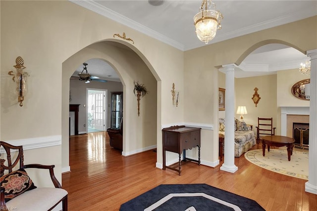 entrance foyer featuring baseboards, wood finished floors, a ceiling fan, and ornamental molding