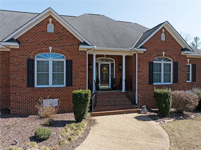 view of front facade featuring brick siding and a shingled roof