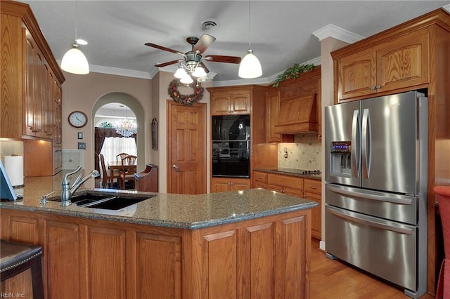 kitchen with brown cabinets, a peninsula, stainless steel refrigerator with ice dispenser, and ceiling fan