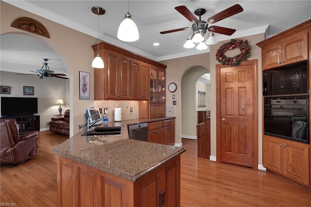 kitchen with arched walkways, a sink, ceiling fan, dishwasher, and black oven