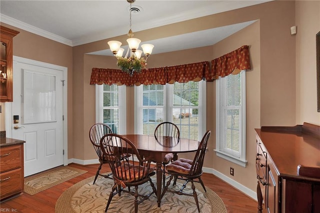 dining area featuring baseboards, wood finished floors, and a chandelier