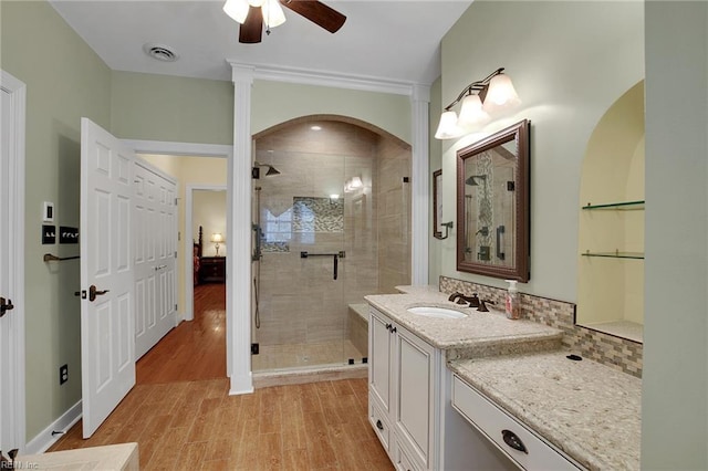 full bath featuring visible vents, wood finished floors, a shower stall, ceiling fan, and vanity