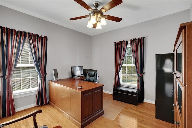 office area featuring baseboards, light wood-style flooring, and a ceiling fan