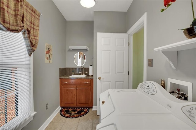 laundry area featuring a sink, baseboards, light tile patterned floors, laundry area, and separate washer and dryer