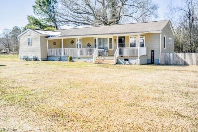 ranch-style house featuring fence, a porch, and a front yard