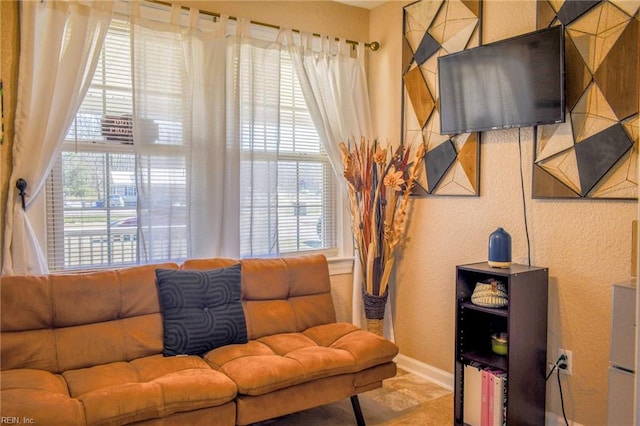 living room with a textured wall, plenty of natural light, and baseboards