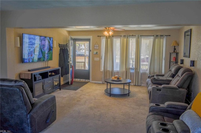 carpeted living room with ceiling fan and baseboards