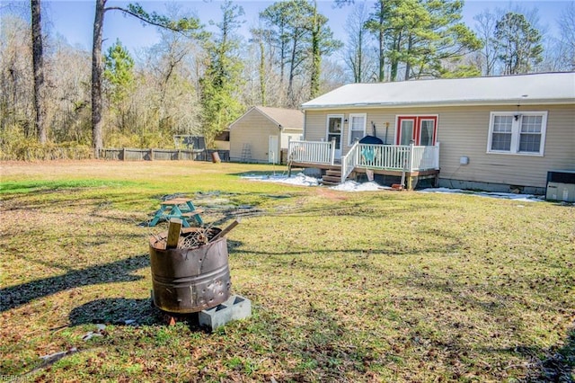 view of yard with central air condition unit, fence, and a deck