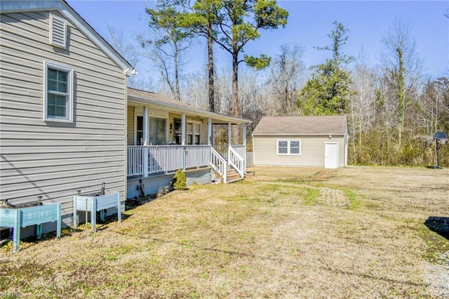 exterior space featuring covered porch, a front lawn, and an outbuilding