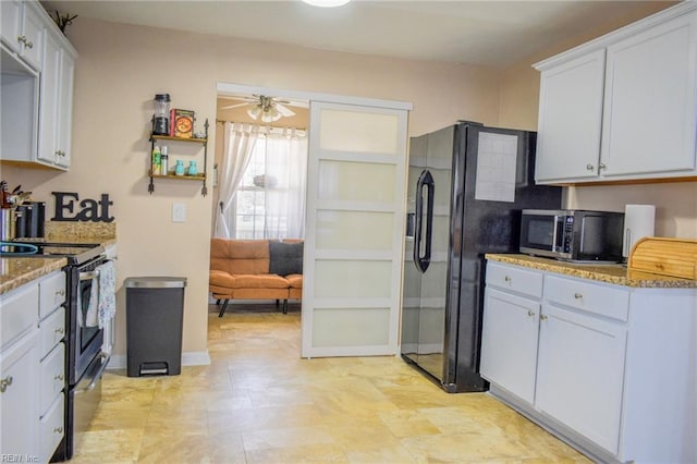 kitchen featuring ceiling fan, appliances with stainless steel finishes, light stone counters, and white cabinetry