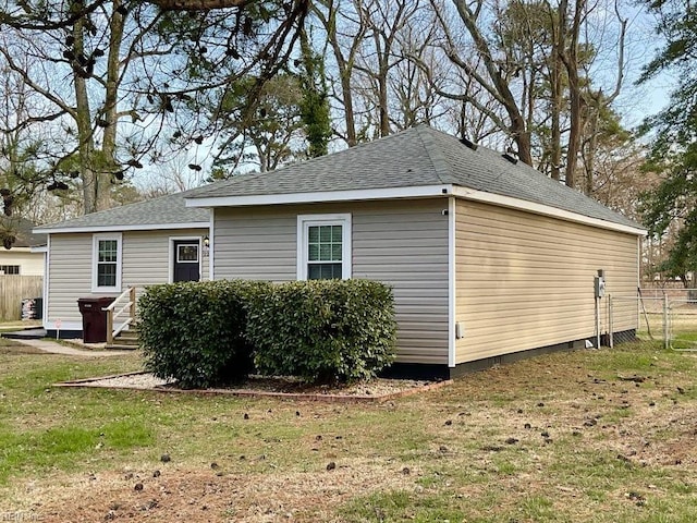 back of house with a lawn and fence