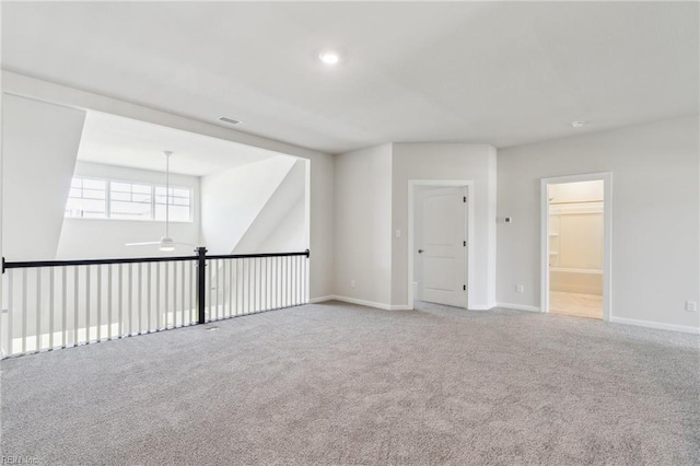 unfurnished room with carpet floors, ceiling fan, visible vents, and baseboards