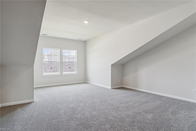 additional living space with vaulted ceiling, carpet, and baseboards