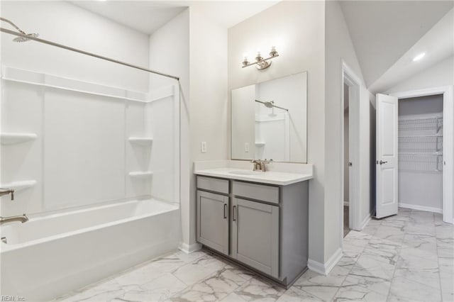 full bathroom featuring lofted ceiling, marble finish floor, washtub / shower combination, and baseboards