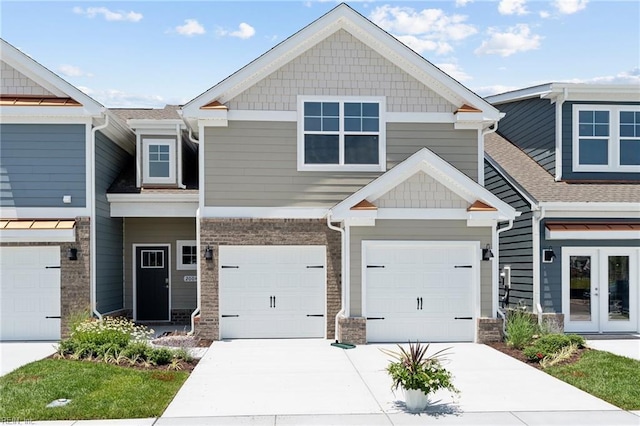 view of front facade featuring a garage, french doors, brick siding, and driveway