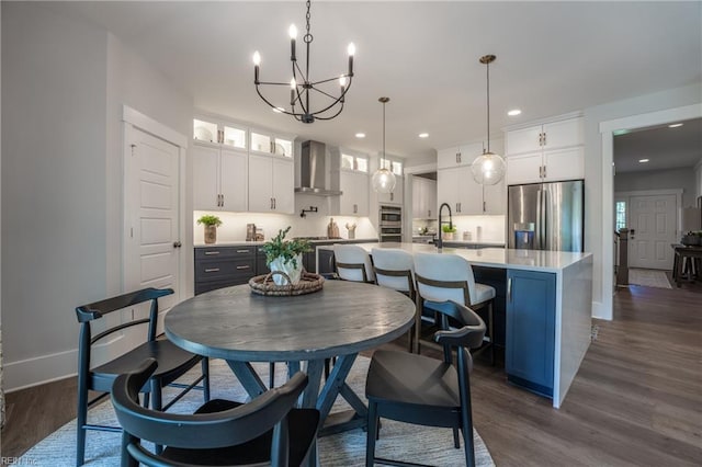dining space featuring recessed lighting, a notable chandelier, baseboards, and dark wood finished floors