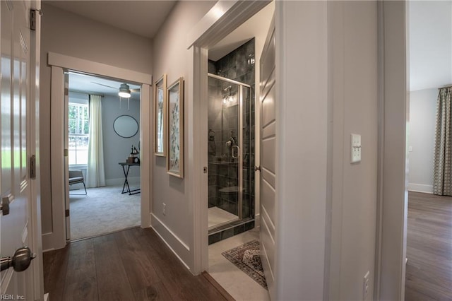 corridor with dark wood-style floors and baseboards