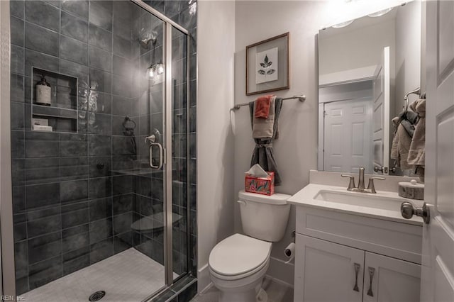 bathroom with toilet, vanity, and a shower stall