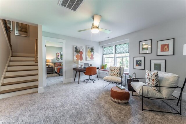 sitting room with stairway, carpet, baseboards, ceiling fan, and visible vents