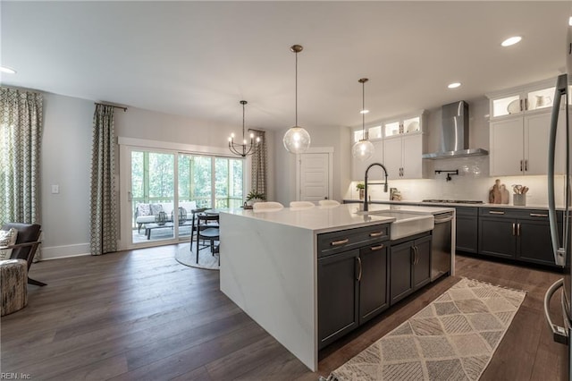 kitchen featuring dark wood finished floors, stainless steel appliances, wall chimney exhaust hood, and tasteful backsplash