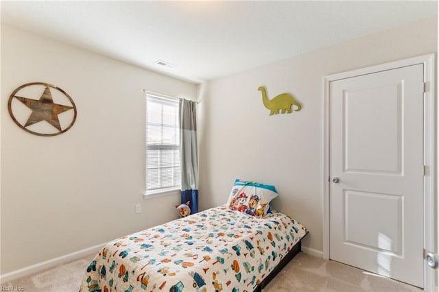 bedroom with light colored carpet, visible vents, and baseboards