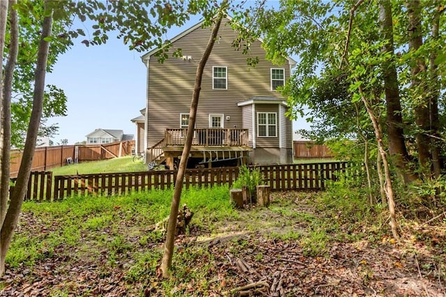 back of house featuring a deck, a yard, and a fenced backyard