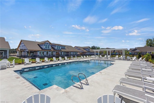 community pool with a patio and fence