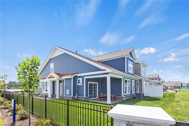 view of front of home featuring fence private yard, a patio area, and a front yard